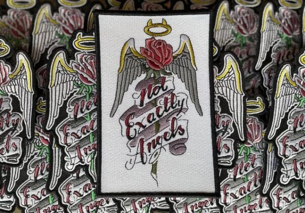 A patch of roses and angel wings with the words " no exactly angels ".